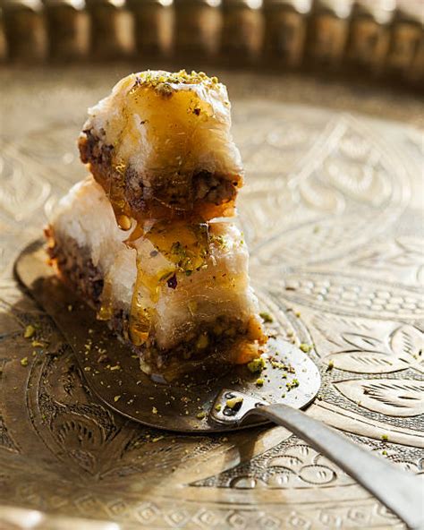 Primer plano de un trozo de baklava con miel goteando.