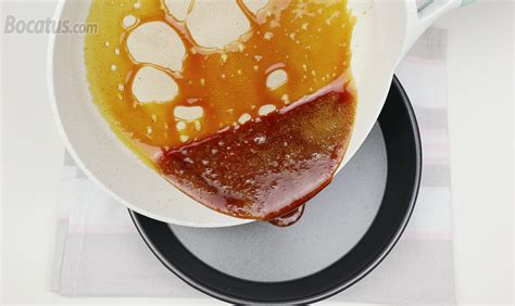 Fotografía de un cazo con caramelo dorado líquido siendo vertido en moldes para flan.