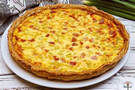 Ilustración de los ingredientes para la quiche de puerros y queso azul, mostrando puerros, bacon, huevos, nata y queso azul.