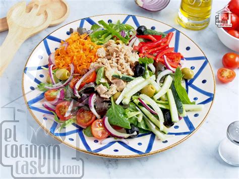 Primer plano de la ensalada terminada, mostrando la disposición de los ingredientes y el brillo de la vinagreta.