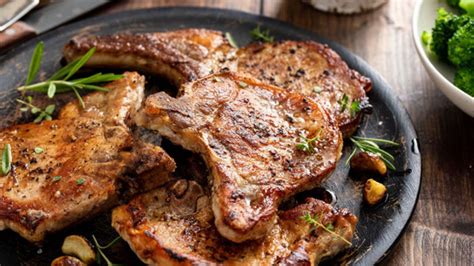 Plato de chuletas de cerdo salseadas con una reducción oscura y brillante de café, acompañadas de guarnición