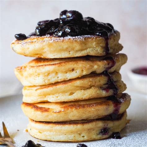 Plato de tortitas de ricotta esponjosas y jugosas decoradas con frutas y un toque de limón