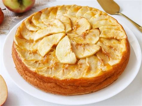 Molde con la masa del kuchen cubierta con puré de manzana y decorada con láminas de manzana.