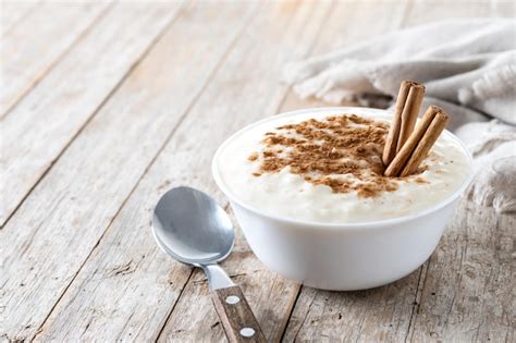 Una foto de arroz con leche cremoso en un tazón decorado con canela en polvo.