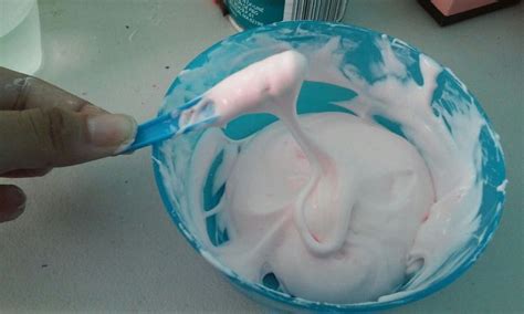 Merengue blanco siendo coloreado con colorante en gel