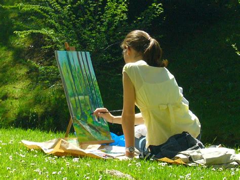 Pintores al aire libre creando arte en un entorno costero, con público observando