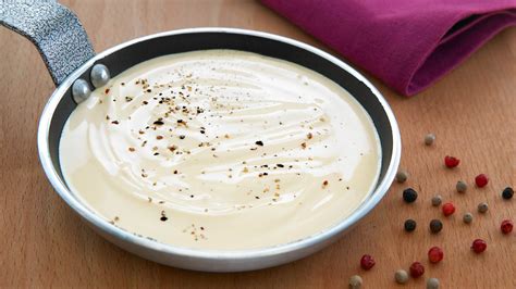 Proceso de elaboración de la salsa bechamel en una cacerola, removiendo con varillas.