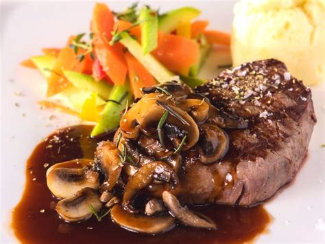 Medallones de lomo de res, champiñones laminados, vino tinto, aceite, tomillo fresco y caldo de costilla en un cuenco