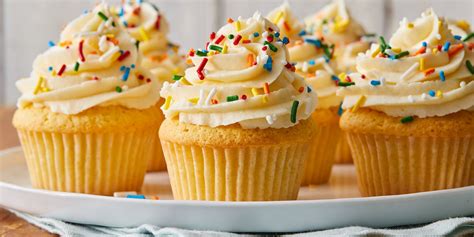 Fotografía profesional de cupcakes de vainilla recién horneados con un copete de crema y decoraciones de corazones de azúcar