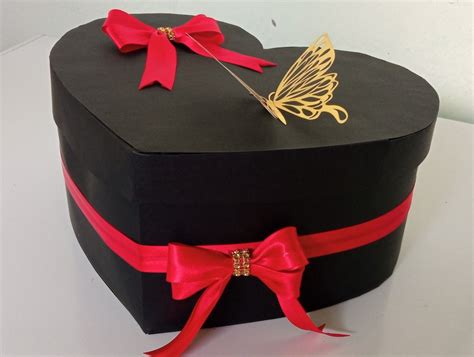 Fotografía de una caja de regalo con bombones en forma de corazón y una tarjeta manuscrita.
