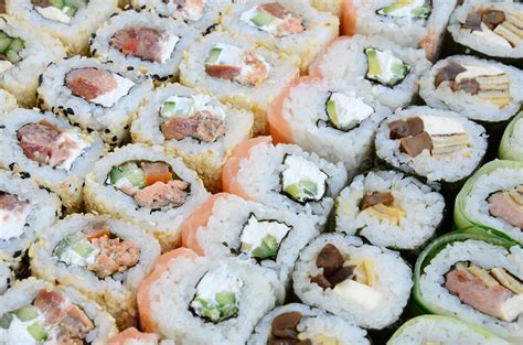 Variedad de rollos de sushi con diferentes coberturas y rellenos.