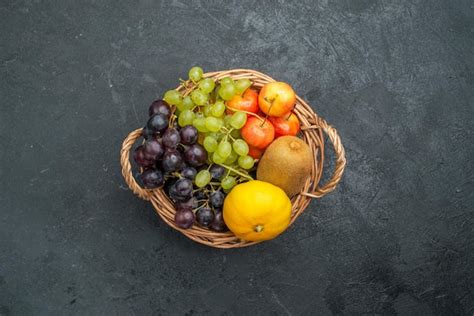 Cesto de frutas frescas y maduras, junto a azúcar, limones y frascos de vidrio esterilizados