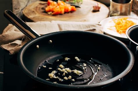 Ramilletes de coliflor rehogándose en una sartén con ajo y aceite de oliva