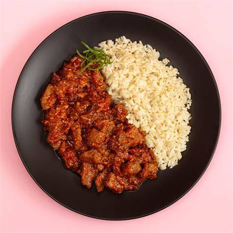 Plato de cerdo agridulce con manzana, acompañado de arroz