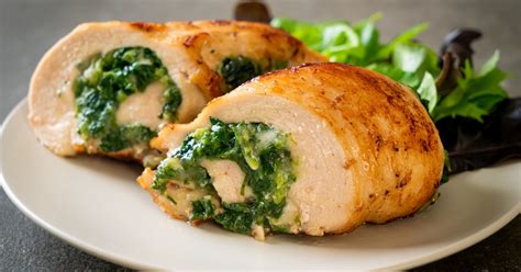 Pechugas de pollo rellenas de espinaca y ricota con un corte transversal que muestra el relleno.