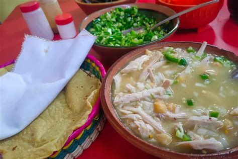 Puesto callejero de caldo de gallina con personas comiendo