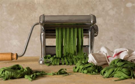 Imagen de una masa de pasta fresca de color verde intenso lista para ser cortada en fettuccini.