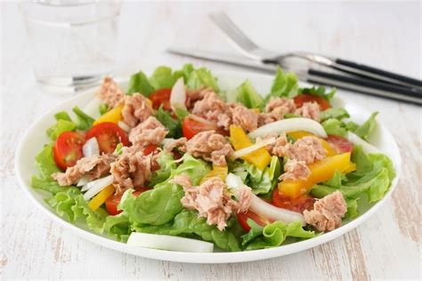 Plato de hamburguesas de atún caseras servidas con una guarnición de ensalada fresca