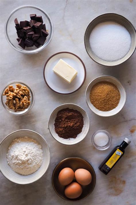 Foto de los ingredientes principales para un brownie: chocolate, mantequilla, huevos, azúcar, harina, nueces.
