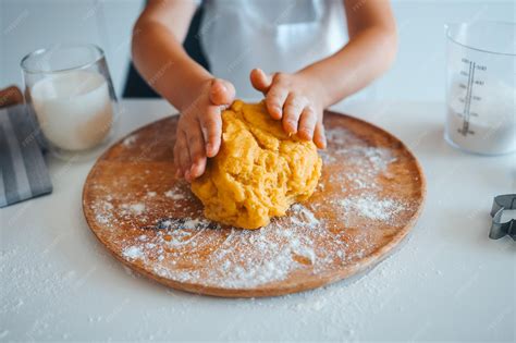 Mano de niño amasando suavemente una bola de masa de pan