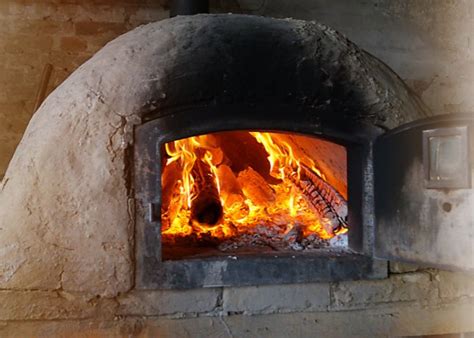 foto de un horno de barro profesional a alta temperatura mostrando una pizza napolitana con el borde alveolado