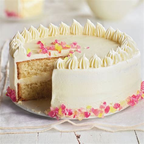 Fotografía de un pastel de chocolate blanco decorado con zarzamoras y lluvia de azúcar glass