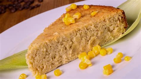 Rebanada de pan de elote con queso, mostrando su textura húmeda y granos de elote.