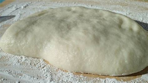 Masa de mochi estirada sobre papel de hornear con fécula de maíz.