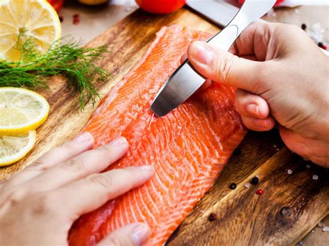 primer plano de cómo retirar las espinas de un filete de salmón con pinzas