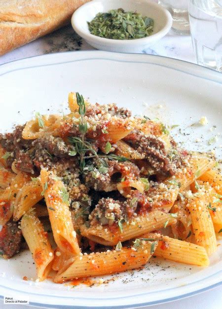Plato de penne rigate con tiras de carne especiada y sofrito de verduras.