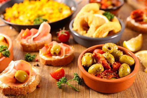 Mesa con diferentes tipos de antipastos, destacando uno de berenjenas y pimientos