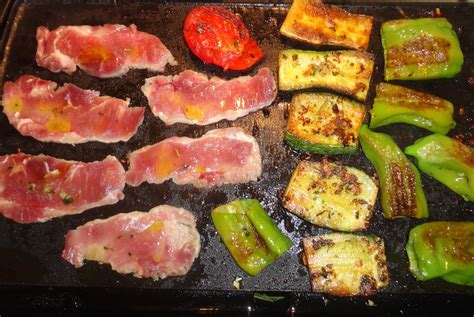 Berenjenas y pimientos cocinándose en una plancha