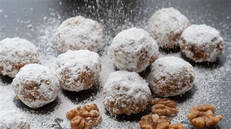 Galletas de nuez siendo cubiertas con azúcar glas