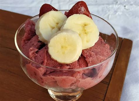 Fotografía profesional de helados veganos de banana y frutilla en paleta con textura cremosa