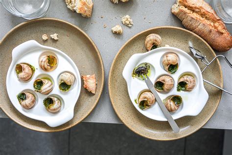 Plato de escargots con mantequilla y ajo, servidos en sus conchas