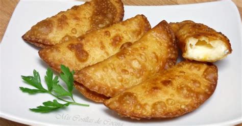 Fotografía de primer plano de empanadillas de queso recién salidas del horno con un toque de orégano.