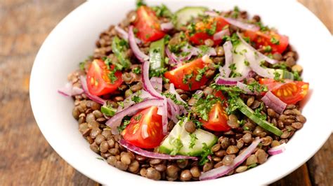 Variedad de platos veganos mediterráneos caseros: hummus, ensalada de lentejas, verduras asadas