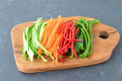 Verduras cortadas en juliana salteándose en una sartén.