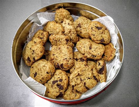 Imagen de galletas de trigo sarraceno con nibs de cacao sobre una superficie rústica de madera.