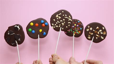 Fotografía de primer plano de paletas de chocolate decoradas con diferentes toppings y texturas.