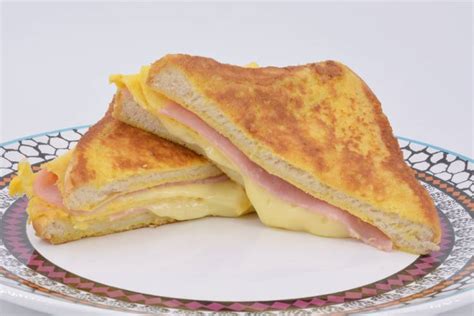 Sándwich de jamón y queso dorado y crocante en un plato