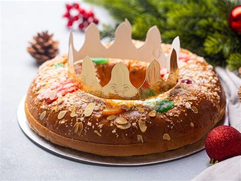 Imagen de un Roscón de Reyes tradicional decorado, mostrando su interior con sorpresas.