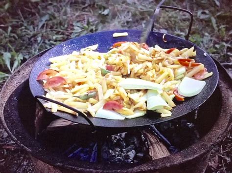 Foto de un disco de arado con comida recién preparada, destacando la versatilidad de cocción