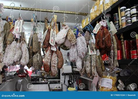Fotografía de cámara de curado con embutidos colgados en ambiente controlado.