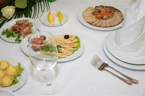 Imagen de una mesa servida con empanadas de pino, vasos de mote con huesillo y una fuente de pajaritos dulces con merengue