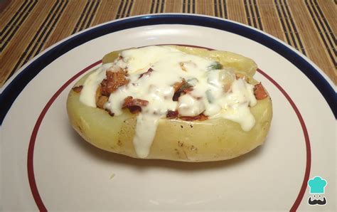 Fotografía de moldes individuales de papas horneadas con queso gratinado y hierbas frescas