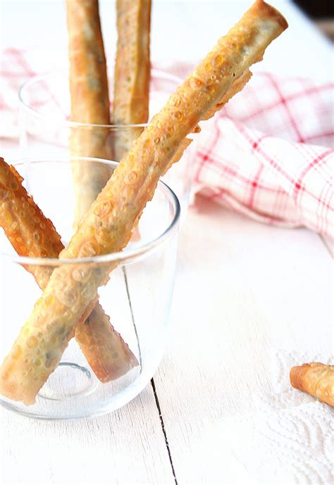 Fotografía apetitosa de cigarrillos de morcilla y manzana servidos como aperitivo.