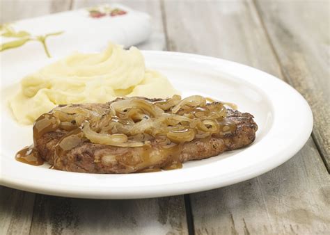 Foto de bifes cocidos en salsa con cebolla