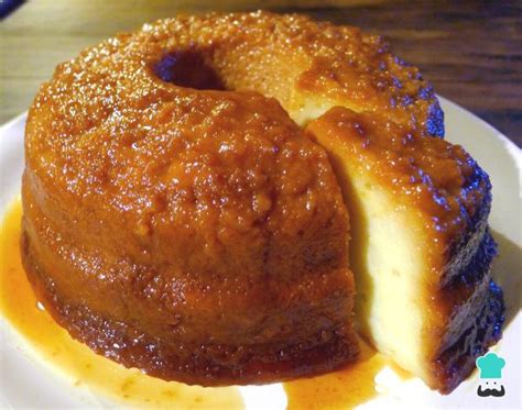 Fotografía de un budín de pan casero servido en un plato, mostrando su textura suave y el caramelo brillante por encima.