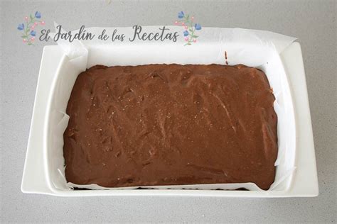 Molde para turrón forrado con papel de horno y espolvoreado con azúcar glas.